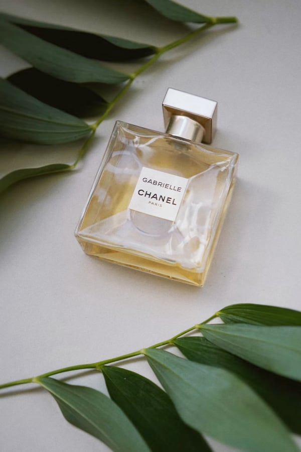 picture of perfume on flat surface with leaves